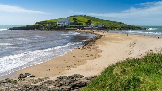 A coastal beach with a grassy hill and a white building with multiple windows. - 1 Bed in Totnes (oc-88098) (North Huish)