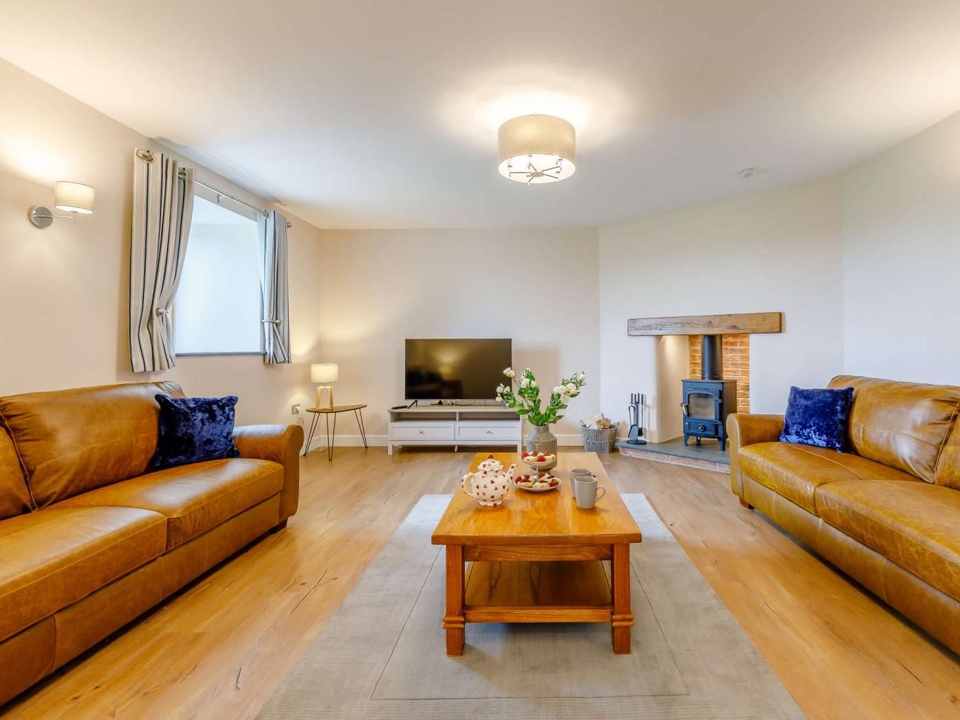 A modern living room with a sofa set, a coffee table, a TV, and a fireplace.