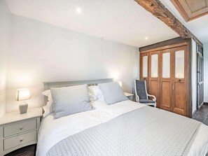 A bedroom with a large bed, a nightstand, a chair, and a wooden wardrobe. - 5 Bed in Kendal (oc-88095) (Skelsmergh)