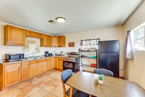 A compact kitchen with wooden cabinets, a microwave, stove, and a refrigerator. - Dog Friendly home walking distance to downtown (Superior)
