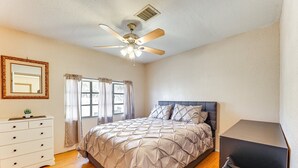 A bedroom with a bed, a dresser, a ceiling fan, and a window with curtains. - Dog Friendly home walking distance to downtown (Superior)