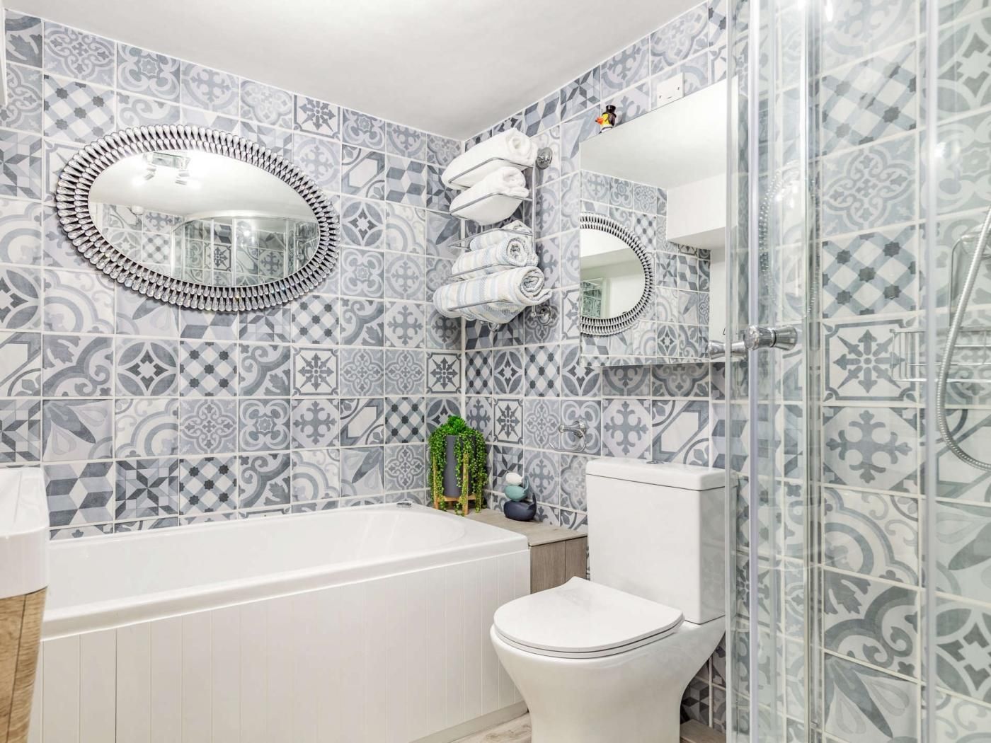 A bathroom with a bathtub, toilet, and a shower area.