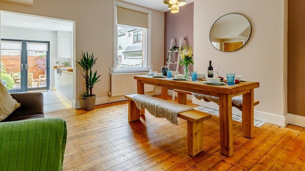 Un espace repas comprenant une table en bois, un banc et un luminaire suspendu.