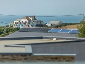 Ein Gebäude mit Solaranlage auf dem Dach, ein Schild für ein Strandhaus und ein Geschäft namens 'FISH & FARM SHOP'.