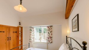 A bedroom with a bed, a wardrobe, a window with curtains, a radiator, and a picture on the wall. - 3 Bed in Pickering (oc-88956) (Newton-on-Rawcliffe)