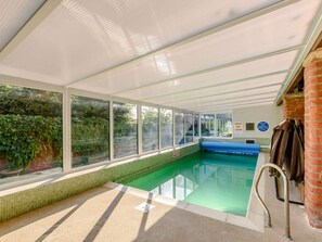 An indoor swimming pool with clear glass walls, a tiled floor, and a bench. - 3 Bed in Pickering (oc-88956) (Newton-on-Rawcliffe)