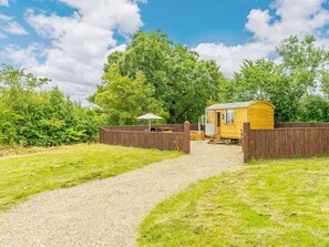 A wooden cabin with a gravel path leading to it, surrounded by greenery and trees. - 1 Bed in Darlington (oc-88970) (Stapleton)