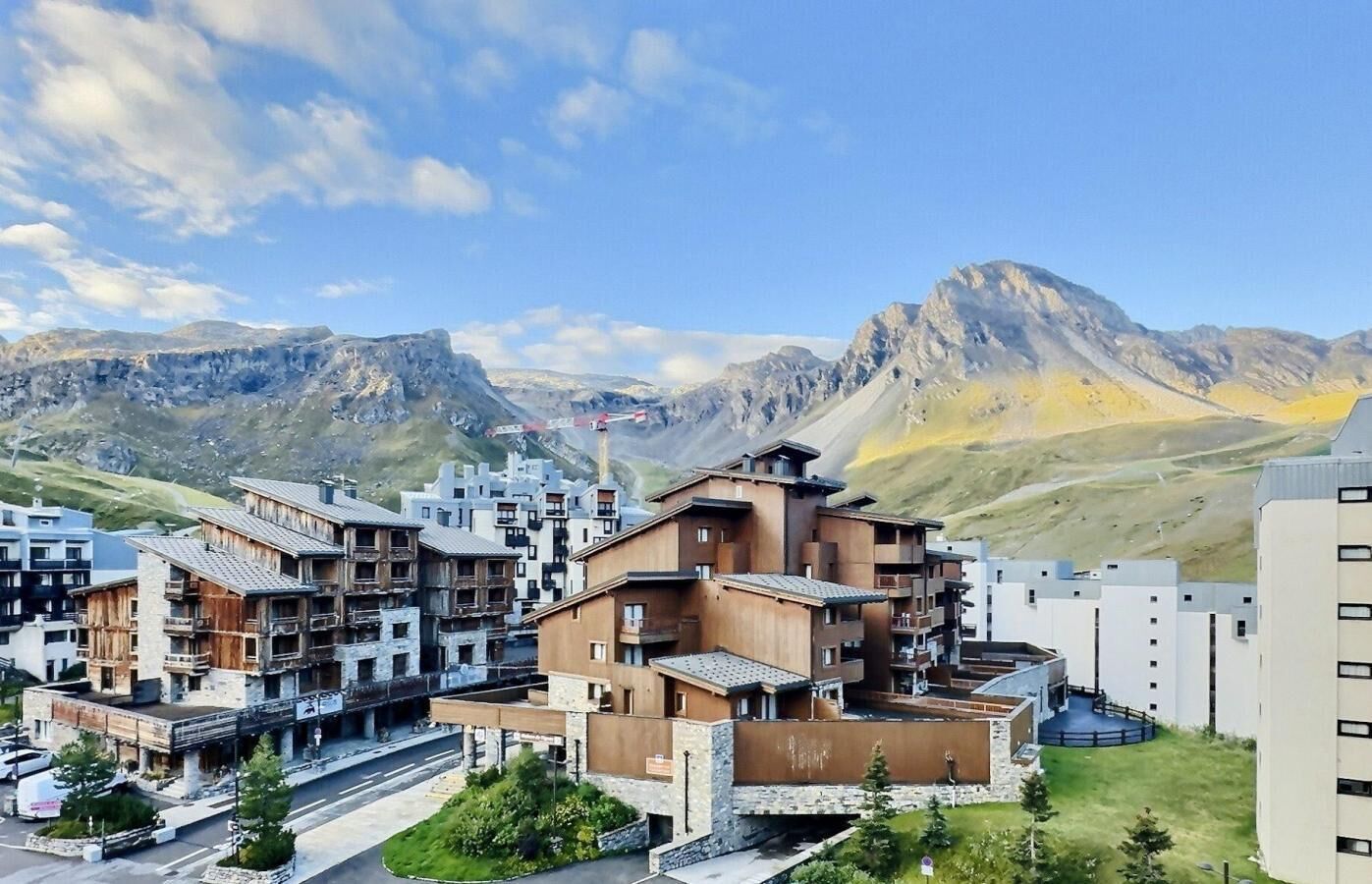 A mountain resort with multi-story buildings, a central courtyard, and a view of the surrounding mountains.