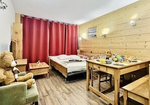 A room with a bed, a wooden table with breakfast items, a chair, a small table with a lamp, and a teddy bear. - 200m from ski slopes, 5th floor, view ski slopes, balcony, tv, 33m², Tignes (Tignes)