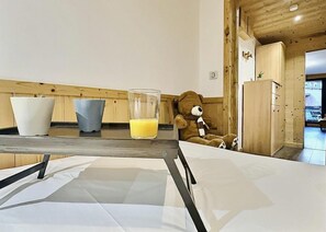 A kitchen with a table, two bowls, a glass of orange juice, and a teddy bear. - 200m from ski slopes, 5th floor, view ski slopes, balcony, tv, 33m², Tignes (Tignes)