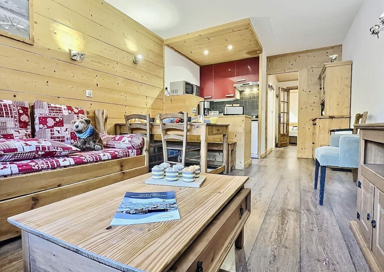 Un interior de madera con sofá, mesa de comedor y zona de cocina.