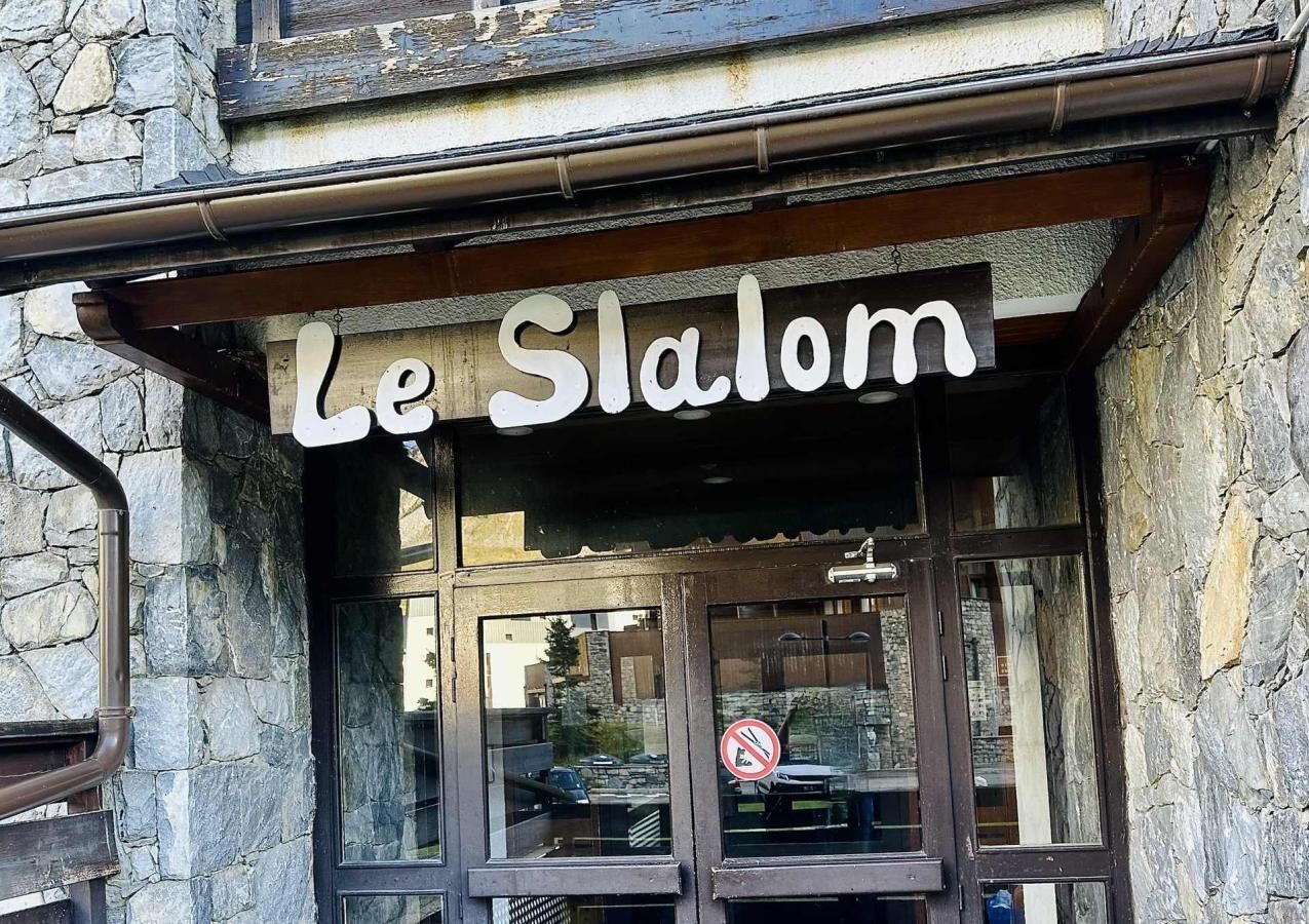 Un bâtiment à la façade en pierre, sur lequel on peut lire l’inscription « Le Slalom ».