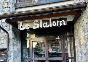 Un bâtiment à la façade en pierre, sur lequel on peut lire l’inscription « Le Slalom ».