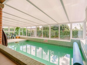 An indoor swimming pool with clear glass walls, a tiled floor, and a view of greenery outside. - 3 Bed in Pickering (oc-88958) (Newton-on-Rawcliffe)