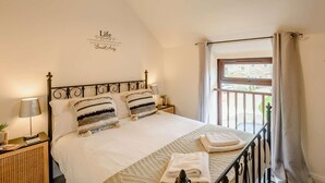 A bedroom with a bed, bedside lamps, a window with curtains, a wall quote, and a small plant. - 2 Bed in Pickering (oc-88957) (Newton-on-Rawcliffe)