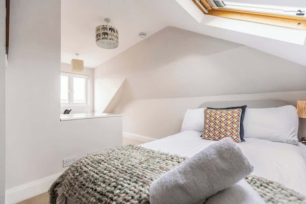 Top-floor bedroom filled with natural light, featuring a dedicated workspace and a comfortable bed — ideal for remote working, relaxing, or unwinding in peace