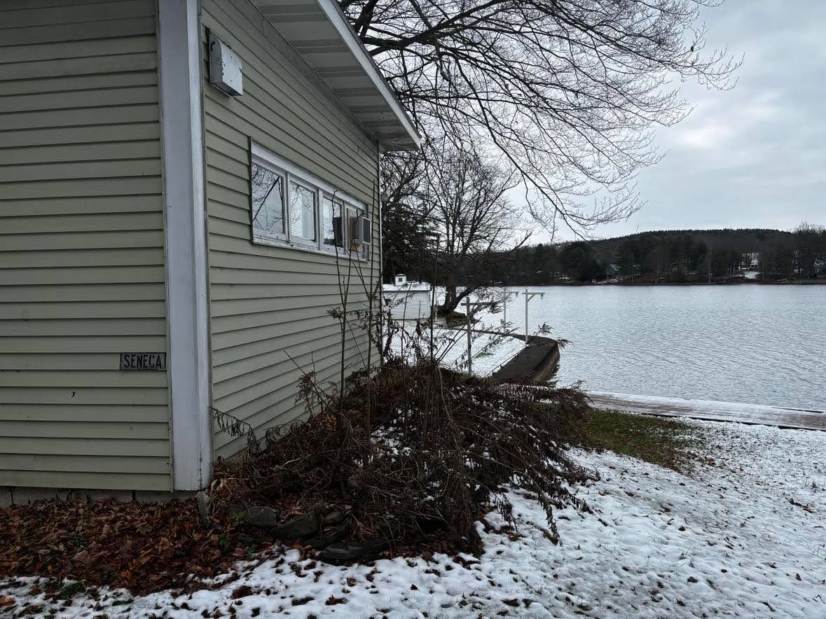 A house with a nameplate reading 'SENECA' next to a body of water.