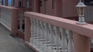 Ein Gebäude mit einer rosafarbenen Fassade und weißen Geländern.