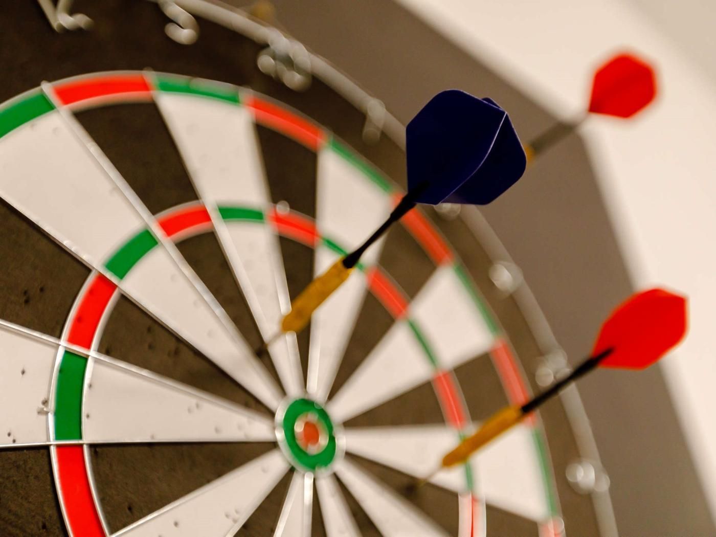 A dartboard with multiple darts stuck in it.