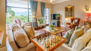 Un salon avec un jeu d’échecs, des canapés, un téléviseur et un tableau accroché au mur.