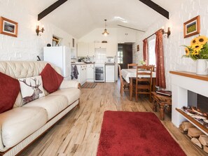 Ein gemütliches Wohnzimmer mit einer Couch, einem Esstisch und einem Kamin.