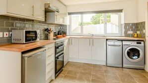 A modern kitchen with stainless steel appliances, a dishwasher, and a window providing natural light. - 2 Bed in Cardigan (oc-89315) (Tresaith)