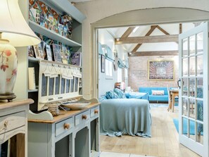 A cozy room with a wooden desk, a lamp, a bookshelf, and a blue sofa. - 2 Bed in Ashbourne (oc-89339) (Ednaston)