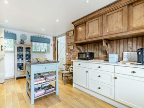 A kitchen with wooden cabinets, a microwave, and a coffee maker. - 2 Bed in Ashbourne (oc-89339) (Ednaston)