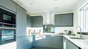 Een moderne keuken met inbouwapparatuur, een centraal eiland en een groot raam.