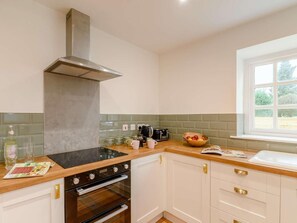 A kitchen with a stove, oven, and a window with a view. - 3 Bed in Rochdale (oc-89552) (Littleborough)