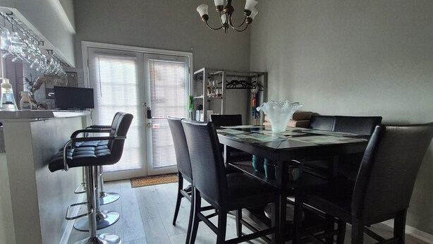 A dining area with a table, chairs, and a chandelier.