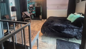 A bedroom with a bed, a desk, a chair, a bookshelf, and a window.