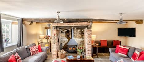 Una sala de estar acogedora con chimenea, dos sofás y una mesa de centro.