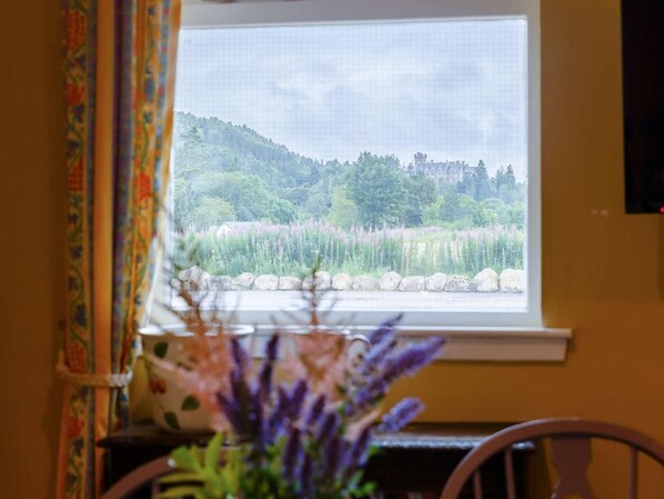 A window with a view of a forested hill and a building in the distance. - 1 Bed in Ardgay (oc-89058) (Ardgay)