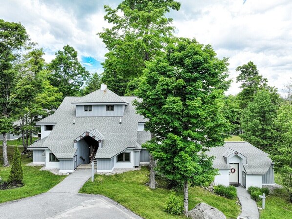 A two-story house with a steeply pitched roof, a front entrance, and a small porch. - Pool, Hot Tub, Spa & Ski Shuttle (Killington)