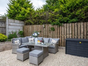 An outdoor patio with wicker furniture, a glass table, and a flower vase. - 3 Bed in Berwick-upon-tweed (oc-89814) (Lowick)