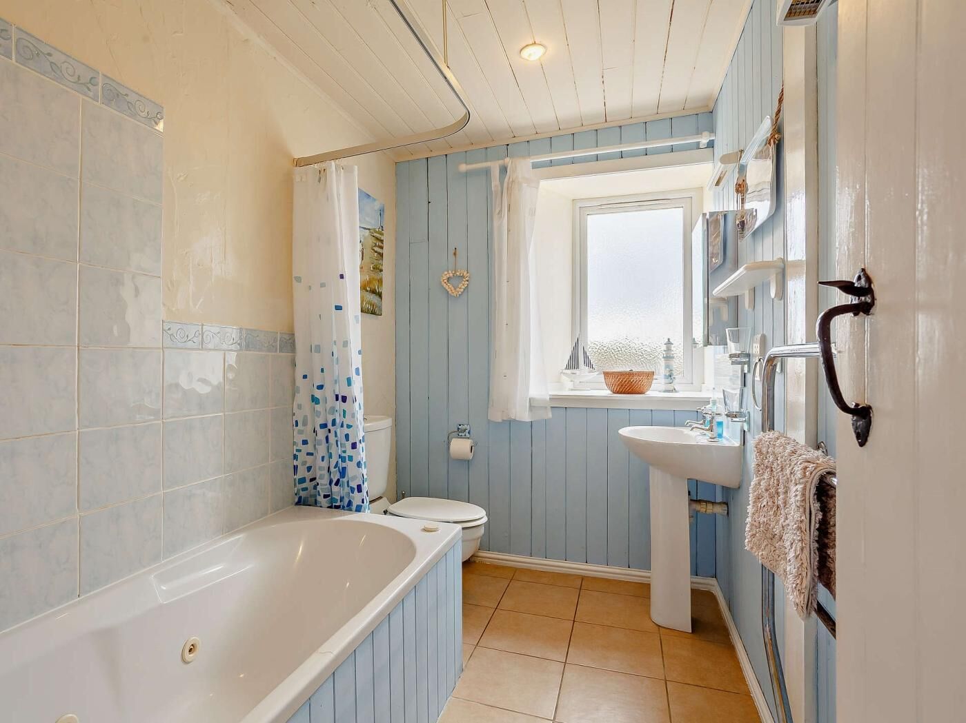 A bathroom with a bathtub, toilet, and sink.