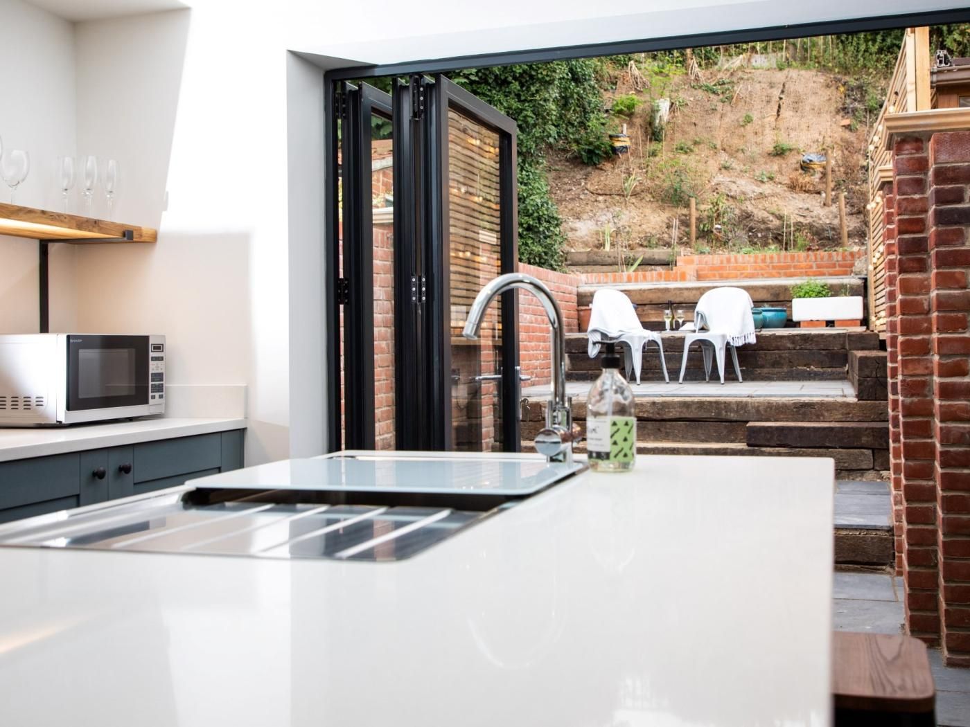 A modern kitchen with a built-in sink and a microwave.