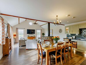 A spacious living area with a dining table set for four, a sofa, and a television. - 3 Bed in Bideford (oc-89869) (Westward Ho!)