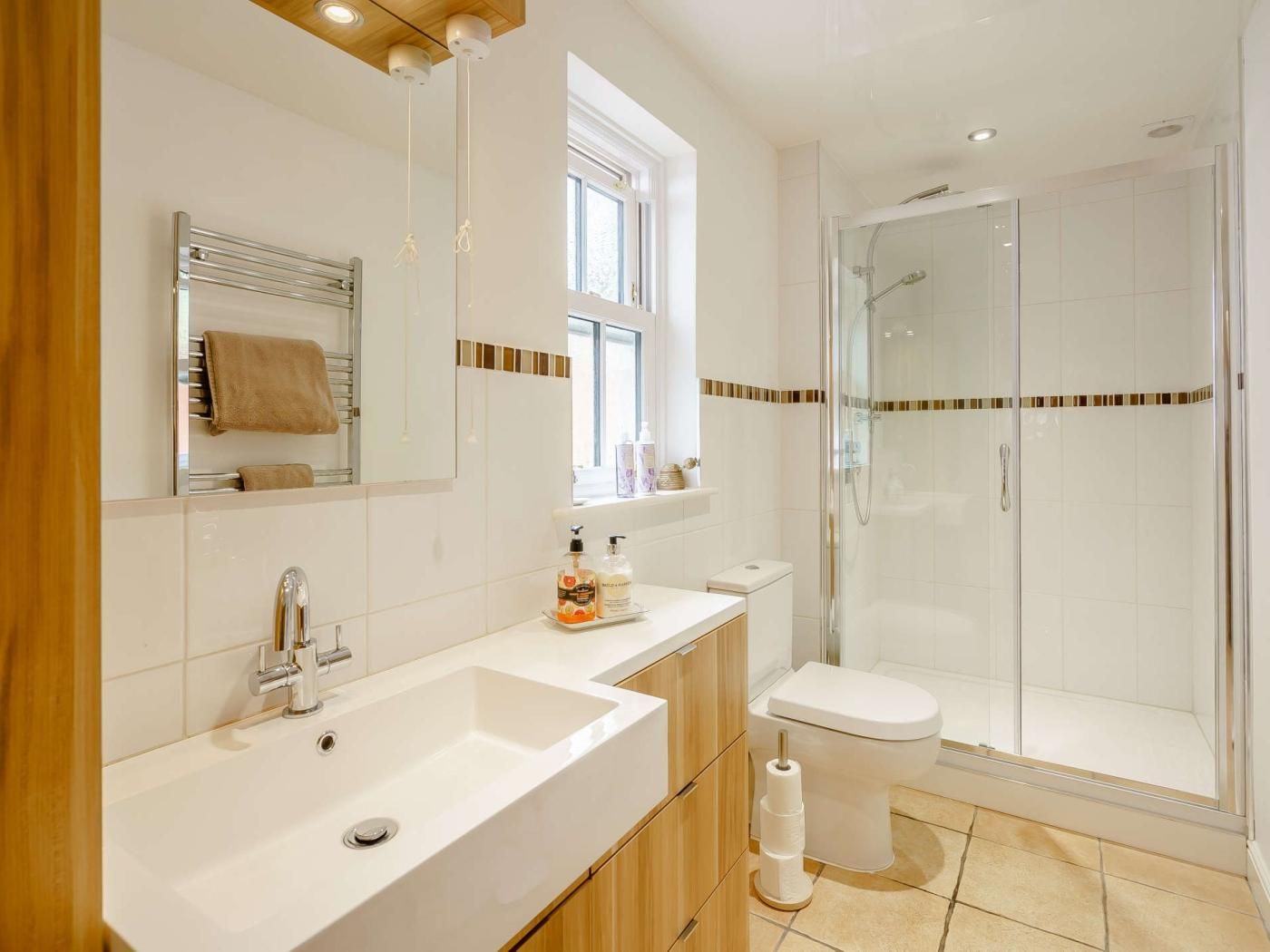 A modern bathroom with a large sink, mirror, and glass shower enclosure.