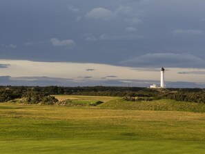 A lighthouse on a grassy hill with a cloudy sky. - 3 Bed in Buckie (oc-89824) (Buckie)