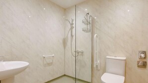 Ein modernes Badezimmer mit einer Duschkabine aus Glas, einer weißen Toilette und einem Waschbecken.