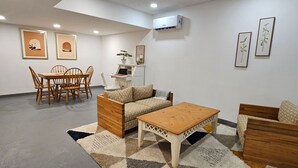 Ein modernes Wohnzimmer mit Sofa, Couchtisch und Esstisch.