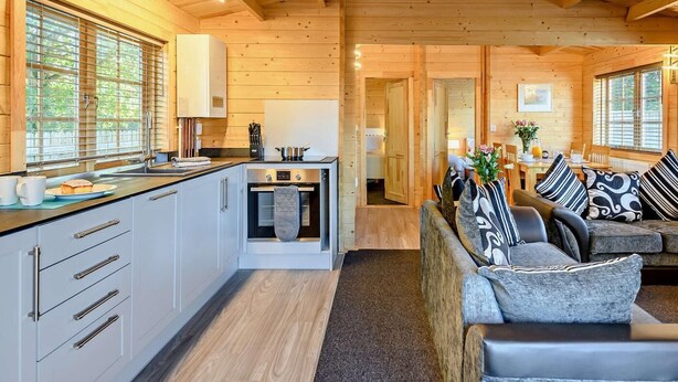 L'intérieur d'une cabane en bois comprend une cuisine, un coin repas et un salon.