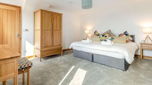Ein Schlafzimmer mit einem Bett, Nachttischen, einem Kleiderschrank und einem Schreibtisch.