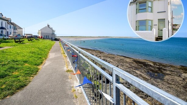 A coastal walkway with a metal railing, a grassy path, and a view of the sea. - 3 Bed in Bideford (oc-89991) (Appledore)