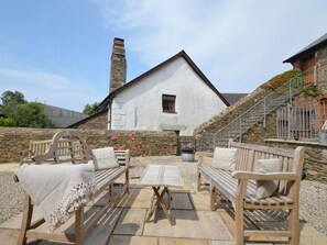 A stone building with a white exterior, a chimney, and a staircase leading to a balcony. - 1 Bed in Kingsbridge (oc-90026) (South Huish)