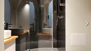 A modern bathroom with a glass-enclosed shower, a sink, and a toilet.