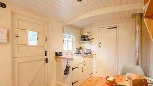 Una cocina acogedora con armarios de madera, un lavabo y una mesa de comedor con pan.