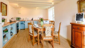 A kitchen with a dining table, chairs, and a chalkboard sign. - 4 Bed in Ayr- (oc-90038) (Ayr)